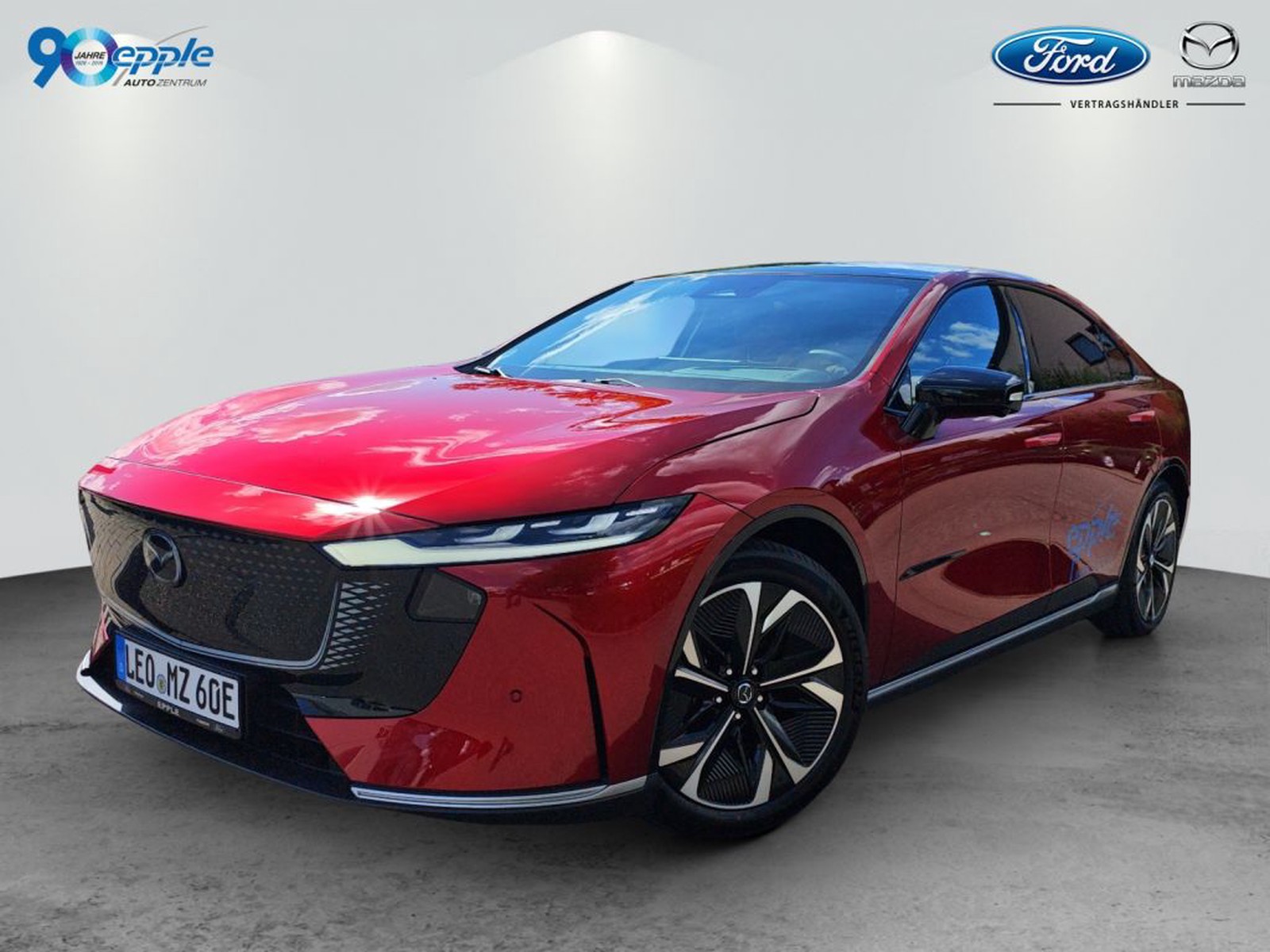 Mazda 6e EV Takumi Plus in rot, Front- und Seitenansicht vor hellem Studiohintergrund