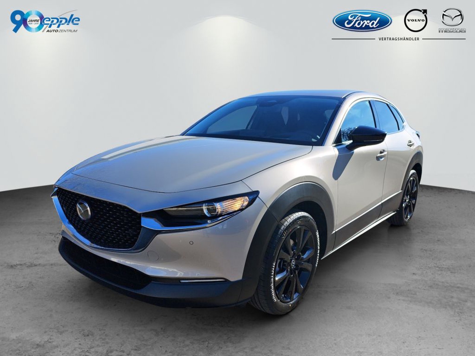 Mazda CX-30 in Platinum Quartz. Front- und Seitenansicht vor hellem Studiohintergrund