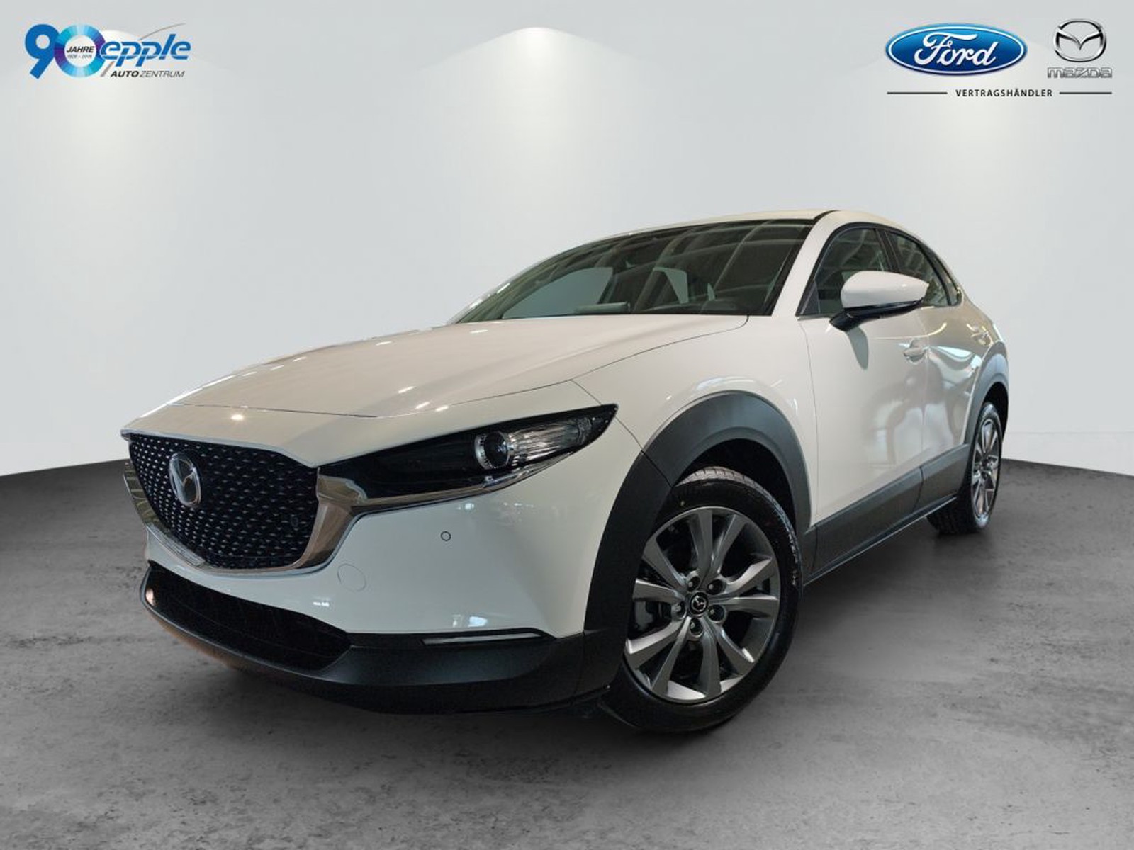 Mazda CX-30 CENTRE LINE in Arctic White. Front- und Seitenansicht vor hellem Studiohintergrund